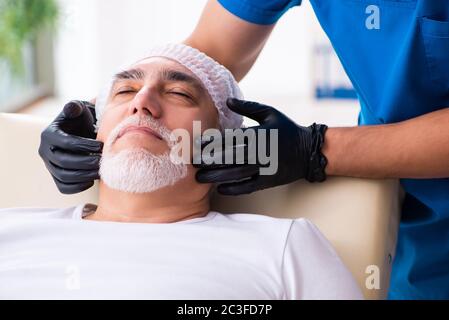 Vieil homme en visite chez un médecin pour une chirurgie plastique Banque D'Images