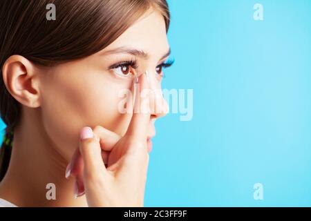 Jolie jeune femme met sur des lentilles de contact pour la vue Banque D'Images