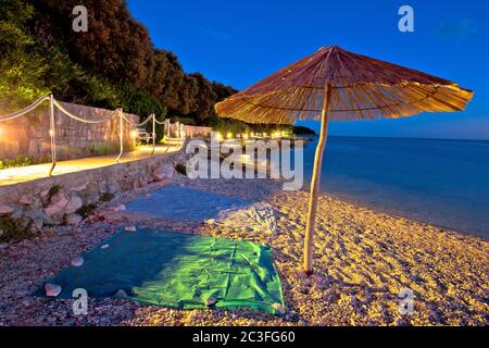 Plage et parasol sur la vue colorée en soirée, mer Adriatique Banque D'Images