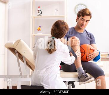 Beau joueur de basket-ball féminin en visite médecin traumatologist Banque D'Images