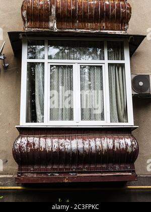 Balcon marron dans un ancien bâtiment résidentiel avec de nouvelles fenêtres Banque D'Images