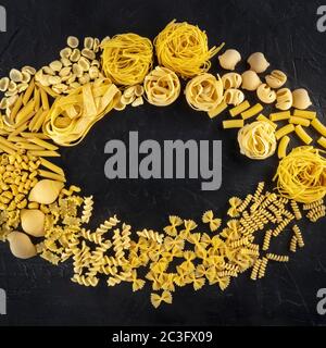 Motif sq de pâtes italiennes avec espace publicitaire, une couche plate de divers types de pâtes, tiré d'en haut sur un fond noir Banque D'Images