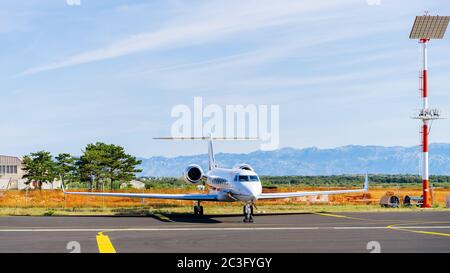 Petit jet privé blanc stationné à l'aéroport Banque D'Images