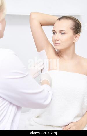 Épilation de cire indésirable. Jeune femme. Traitement de salon de cosmétologie. Épilation à la maison Banque D'Images