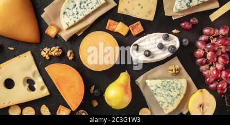 Panorama plat de fromage. De nombreux fromages différents, tirés d'en haut sur un fond sombre Banque D'Images