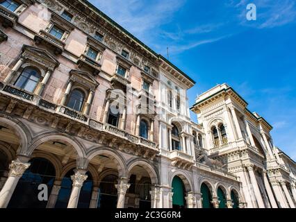 Façade de la galerie Vittorio Emanuele II et ancien beau bâtiment sur la place du Duomo (Piazza del Duomo) à Milan. Ciel bleu. Journée ensoleillée. Banque D'Images