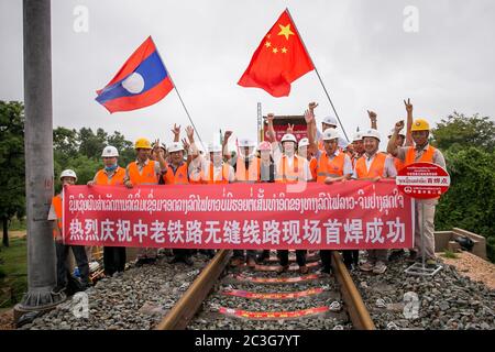 (200620) -- VIENTIANE, 20 juin 2020 (Xinhua) -- les travailleurs du China Railway No.2 Engineering Group (CREC-2) posent pour une photo de groupe après avoir soudé les premiers rails sans soudure pour le chemin de fer Chine-Laos dans la banlieue nord de Vientiane, au Laos, le 18 juin 2020. Le CREC-2 a soudé jeudi matin les premiers rails sans soudure pour le chemin de fer Chine-Laos dans la banlieue nord de Vientiane, capitale du Laos. Le rail sans soudure, également appelé rail soudé continu (CWR) qui élimine les joints de rail, peut améliorer la durée des rails en acier, réduire les coûts d'entretien des locomotives et des rails, impro Banque D'Images