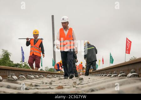 (200620) -- VIENTIANE, 20 juin 2020 (Xinhua) -- les travailleurs du China Railway No.2 Engineering Group (CREC-2) vérifient les rails soudés sans soudure du chemin de fer Chine-Laos dans la banlieue nord de Vientiane, au Laos, le 18 juin 2020. Le CREC-2 a soudé jeudi matin les premiers rails sans soudure pour le chemin de fer Chine-Laos dans la banlieue nord de Vientiane, capitale du Laos. Le rail sans soudure, également appelé rail soudé en continu (CWR) qui élimine les joints de rail, peut améliorer la durée des rails en acier, réduire les coûts d'entretien des locomotives et des rails, améliorer la stabilité et la vitesse de t Banque D'Images