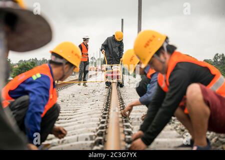 (200620) -- VIENTIANE, 20 juin 2020 (Xinhua) -- les travailleurs du China Railway No.2 Engineering Group (CREC-2) visent les rails soudés sans soudure du chemin de fer Chine-Laos dans la banlieue nord de Vientiane, au Laos, le 18 juin 2020. Le CREC-2 a soudé jeudi matin les premiers rails sans soudure pour le chemin de fer Chine-Laos dans la banlieue nord de Vientiane, capitale du Laos. Le rail sans soudure, également appelé rail soudé en continu (CWR) qui élimine les joints de rail, peut améliorer la durée des rails en acier, réduire les coûts d'entretien des locomotives et des rails, améliorer la stabilité et la vitesse de t Banque D'Images