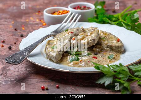 Foie de boeuf dans la crème sure avec le persil. Banque D'Images