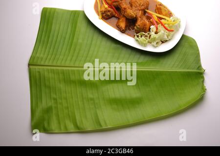 Feuille de banane , feuille de Kerala sadya, une plaque traditionnellement utilisée pendant la fête et les festivals, image isolée de feuille de banane verte fraîche disposée sur blanc Banque D'Images