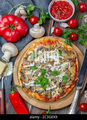 Pizza maison avec tomates, champignons et basilic vert. Banque D'Images