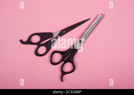 ciseaux pour coupes de cheveux sur fond rose Banque D'Images