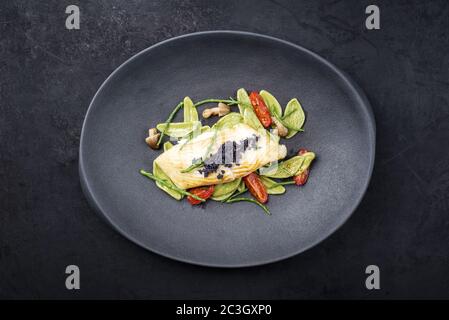 Filet de poisson frit gastronomique italien au bar avec pâtes aux épinards Banque D'Images