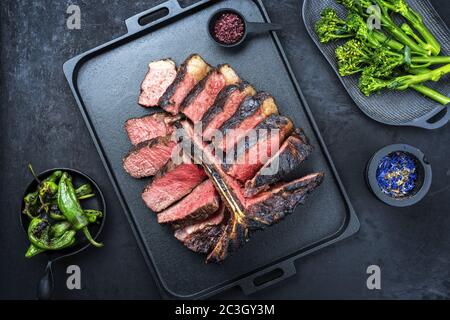 Griller au barbecue le steak de bœuf de porterhouse Wagyu vieilli coupé en tranches avec un grand filet de piment chaud et rabe de brocoli de rapini Banque D'Images