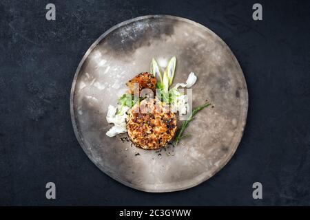 Tartre de saumon gastronomique japonais à base de filet de saumon avec crevettes géantes et nouilles aux épices comme vue de dessus sur un desi moderne Banque D'Images