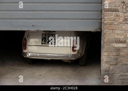 Une vieille voiture utilitaire italienne sort d'un garage dans un hameau italien Banque D'Images