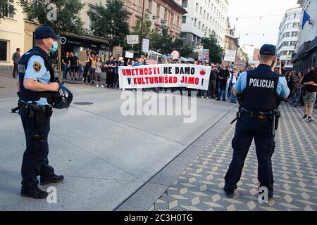 Ljubljana, Slovénie. 19 juin 2020. Des policiers se tiennent devant les manifestants, qui détiennent une grande bannière et des pancartes pour défendre la culture pendant la manifestation.chaque vendredi, des milliers de personnes à Ljubljana et dans d'autres grandes villes slovènes protestent contre le gouvernement du Premier ministre Janez Jansa, en raison d'allégations de corruption et de régime antidémocratique de son gouvernement. Crédit : SOPA Images Limited/Alamy Live News Banque D'Images