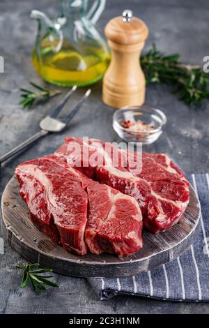 Steak de bœuf cru sur fond gris foncé Banque D'Images