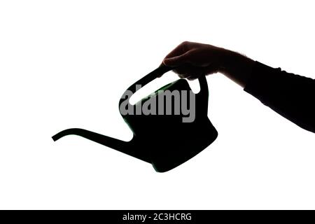 La main d'un jeune homme tient un concept de CAN - silhouette arrosoir Banque D'Images