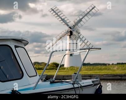 Avant du bateau de plaisance amarré à Thurne Dyke avec le moulin à vent de Thurne tristement célèbre en arrière-plan Banque D'Images