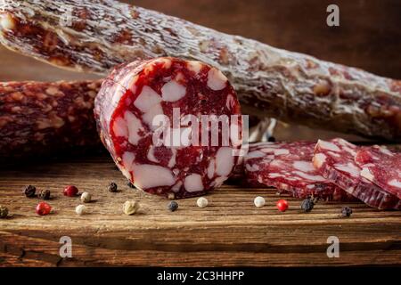 Saucisse traditionnelle et saucisse avec moule. Salami à saucisse tranché sur un panneau de bois avec épices. Gros plan. Banque D'Images