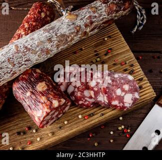 Saucisse traditionnelle et saucisse avec moule. Salami à saucisse en tranches et couteau sur une planche de bois avec épices. Gros plan. Vue du dessus Banque D'Images