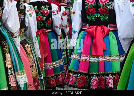 Des filles vêtues de costumes folkloriques nationaux polonais de la région de Lowicz pendant la procession annuelle de Corpus Christi. Jupes traditionnelles colorées à rayures Banque D'Images