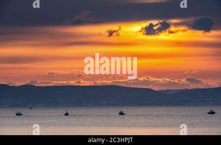 Japon bateaux de pêche dans la mer au lever du soleil. Sur fond de l'île de Kunashir. Japon. La zone d'eau de Hokkaido. Détroit de Kunashir. Mer de Banque D'Images