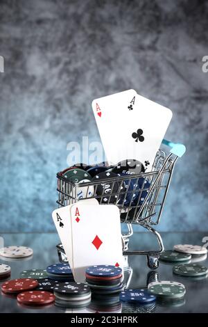 Une paire d'as, de coeurs et de diamants, sur un jeu de cartes à jouer. Poker jouant des jetons dans un panier bleu sur un fond bleu foncé et bleu clair. Banque D'Images