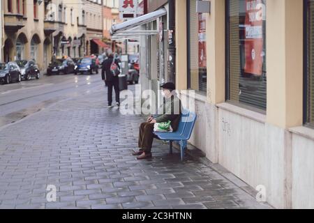 MUNICH, ALLEMAGNE - 02 mai 2020 : un senior est assis seul à un arrêt de tramway en attente du tramway à Munich, Allemagne. Protection contre le coronavirus par fa Banque D'Images