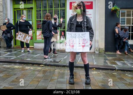 Chippenham, Wiltshire, Royaume-Uni. 20 juin 2020. Une femme tient un écriteau disant que le royaume-uni n'est pas innocent dans une affaire de vies noires BLM de protestation dans la ville de la place du marché. Le rassemblement a été organisé pour que les habitants de la région attirent l'attention sur le racisme au Royaume-Uni et pour manifester leur solidarité avec d'autres manifestations de BLM qui ont eu lieu dans le monde entier après la mort de George Floyd qui est mort en garde à vue le 25 mai à Minneapolis. Credit: Lynchpics/Alamy Live News Banque D'Images