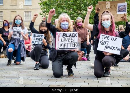 Chippenham, Wiltshire, Royaume-Uni. 20 juin 2020. Les manifestants de BLM tiennent des pancartes et des panneaux BLM alors qu'ils prennent le genou lors d'un rassemblement de protestation de BLM de Black Lives Matter dans la place du marché de la ville. Le rassemblement a été organisé pour que les habitants de la région attirent l'attention sur le racisme au Royaume-Uni et pour manifester leur solidarité avec d'autres manifestations de BLM qui ont eu lieu dans le monde entier après la mort de George Floyd qui est mort en garde à vue le 25 mai à Minneapolis. Credit: Lynchpics/Alamy Live News Banque D'Images