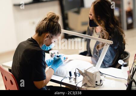 Manucure peint les ongles avec gel vernis sur les ongles des clients. Banque D'Images