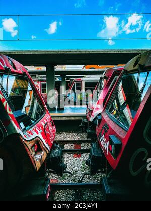 Coup de feu d'une gare abandonnée avec des trains rouges et quelques éléments d'art de rue sur eux Banque D'Images