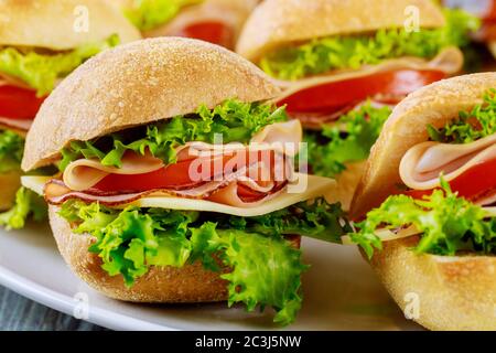 Délicieux sandwichs préparés avec du jambon, du fromage, de la laitue et de la tomate. Gros plan. Banque D'Images
