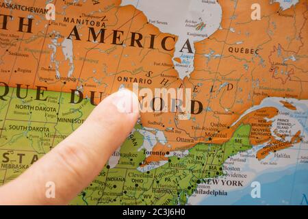 'RAK, RAK/eau - 4/12/2020: Doigt pointant vers une carte de pays colorée en anglais et en français de l'Ontario, Canada. ' Banque D'Images