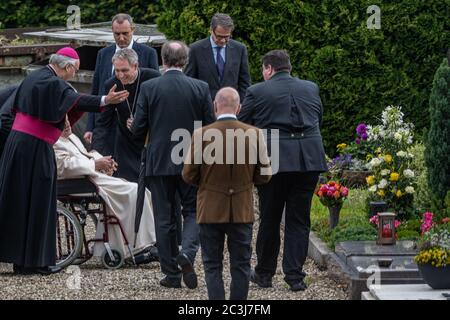 Ratisbonne, Allemagne. 20 juin 2020. Le pape éréitus Benoît XVI (2e à partir de la gauche) visite la tombe de ses parents et de sa sœur en fauteuil roulant au cimetière de Ziegetsdorf près de Regensburg. Benoît XVI restera au moins pour le week-end dans son vieux pays. Crédit : Armin Weigel/dpa/Alay Live News Banque D'Images