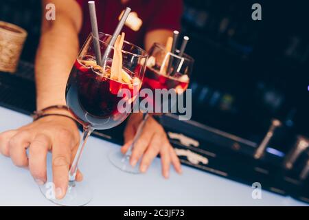 Barman tenant un cocktail près d'un ustensile passoire boisson saine sur un comptoir de bar. Vue professionnelle . Boisson alcoolisée tendance. Concevoir des personnes Banque D'Images