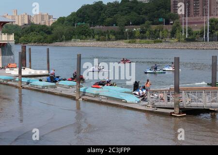 Un groupe de personnes en jet skis au quai devant le Peter Jay Sharp Boathouse sur l'East River ou Harlem River Banque D'Images