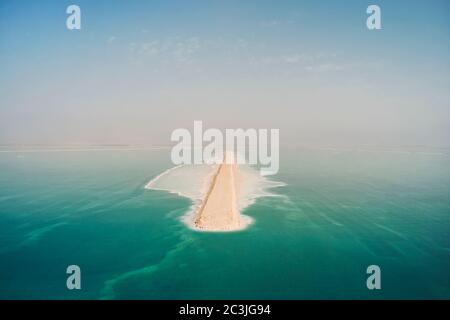 Route sur la surface de la mer Morte. La partie sud de la mer Morte, est divisée en bassins d'extraction de minéraux. Le rivage est recouvert de sel blanc Banque D'Images