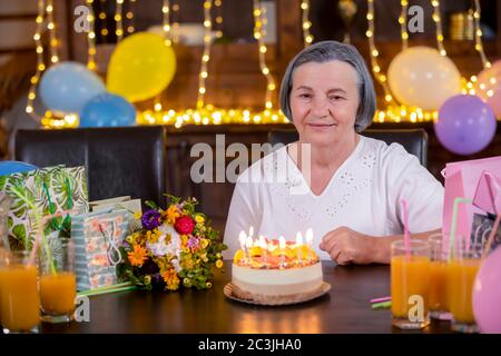 Femme âgée avec gâteau d'anniversaire à l'anniversaire ou fête de la fête de la Fête des mères. Concept de célébration de la vie et de l'amour. Concept de fête des mères. Banque D'Images