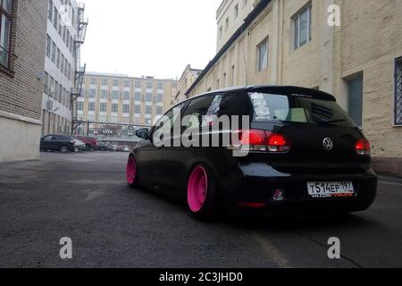 Moscou, Russie - 08 mai 2019 : un Volkswagen Golf 6 noir et discret avec roues faites à la main rose vif se dresse dans la rue. Véhicule sursursurlow avec suspension pneumatique installée. Vue de l'arrière Banque D'Images