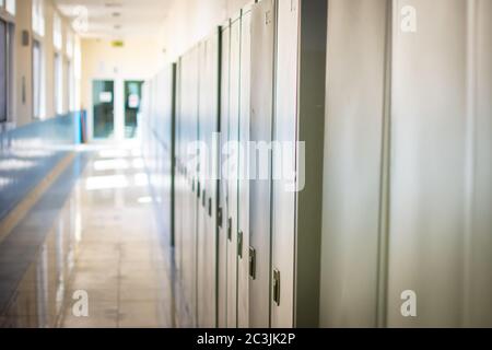 Le couloir vide d'une école secondaire ou d'un collège est fermé pendant la COVID-19 (coronavirus). Les Locers se sont broutés dans le couloir. Banque D'Images