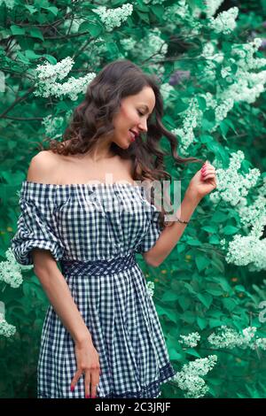 portrait d'une fille souriante en fleurs lilas. Banque D'Images