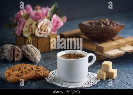 Café du matin avec biscuits et morceaux de sucre de canne, grains de café et fruits secs Banque D'Images