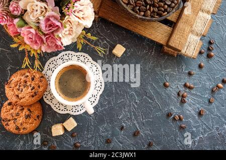 petit déjeuner de style vintage. Une tasse de café avec des morceaux de sucre de canne, des biscuits au chocolat et un vase avec des grains de café. Vue de dessus Banque D'Images