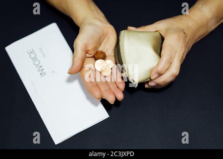 Gros plan d'une femme tenant un portefeuille vide avec des pièces de monnaie dans sa main. Concept de crise économique Banque D'Images