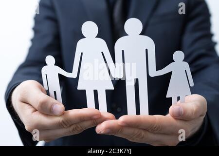 Gros plan d'une personne tenant une découpe de papier de famille sous les feux Banque D'Images