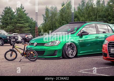 Moscou, Russie - 06 juillet 2019: Tuned Volkswagen Golf 7 serré dans un film de vinyle vert. Roues exclusives installées, suspension pneumatique. LowRider dans le parking. Vue latérale Banque D'Images